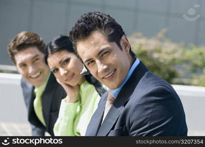 Portrait of a businesswoman smiling with two businessmen