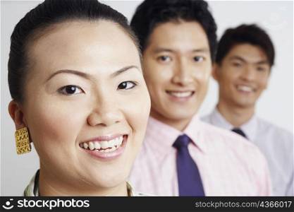 Portrait of a businesswoman smiling with two businessmen