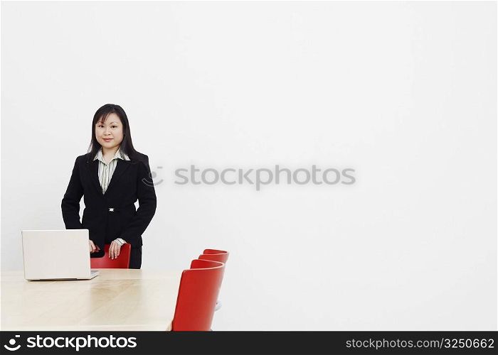 Portrait of a businesswoman standing in a board room and smiling
