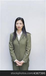 Portrait of a businesswoman standing with her hands clasped