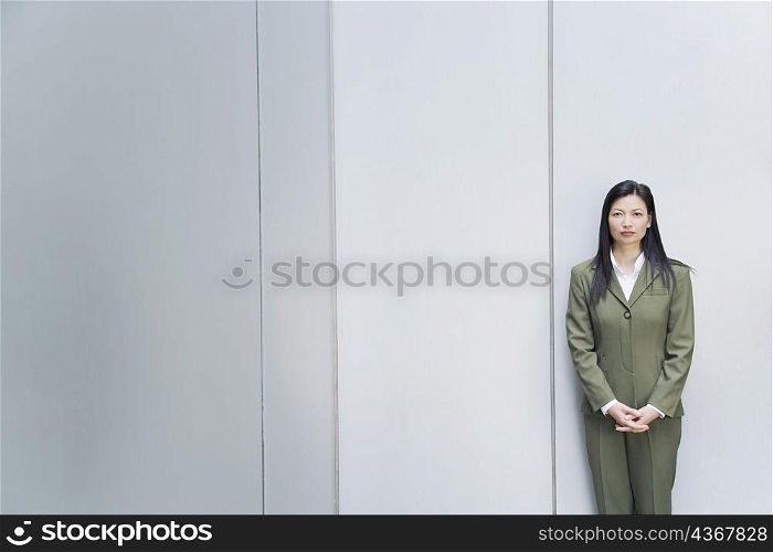 Portrait of a businesswoman standing with her hands clasped