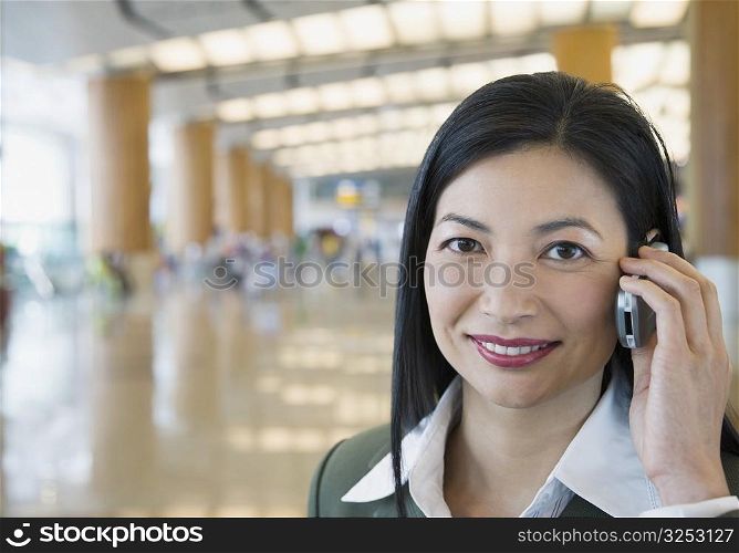 Portrait of a businesswoman talking on a mobile phone at an airport