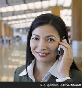 Portrait of a businesswoman talking on a mobile phone at an airport