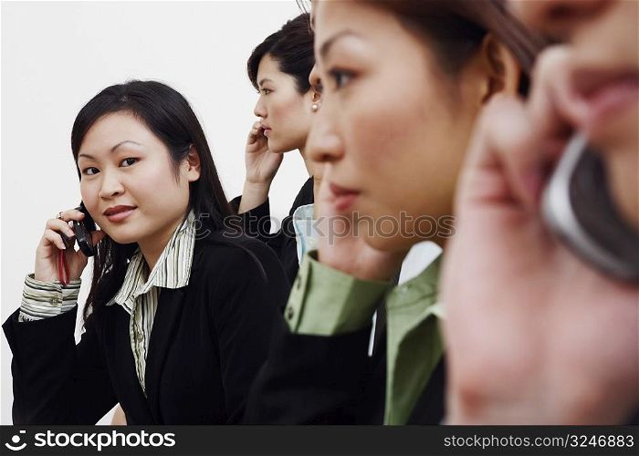 Portrait of a businesswoman talking on a mobile phone with his colleagues