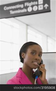 Portrait of a businesswoman talking on a pay phone and smiling