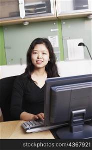 Portrait of a businesswoman using a computer smiling