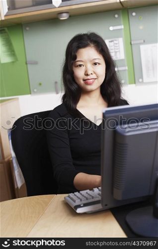 Portrait of a businesswoman using a computer smiling