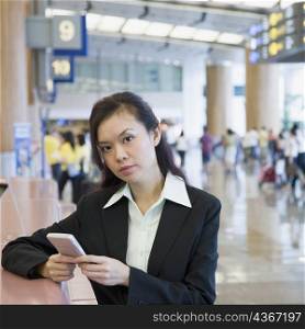 Portrait of a businesswoman using a hand held device at an airport