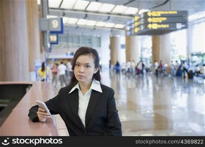 Portrait of a businesswoman using a hand held device at an airport