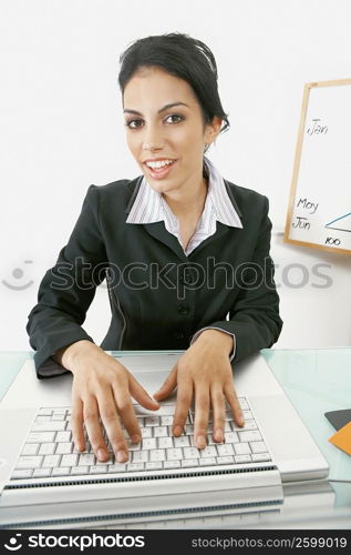 Portrait of a businesswoman using a laptop and smiling