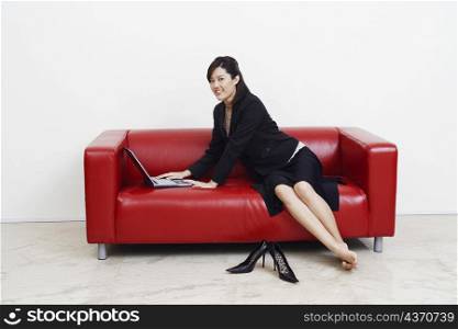 Portrait of a businesswoman using a laptop and smiling