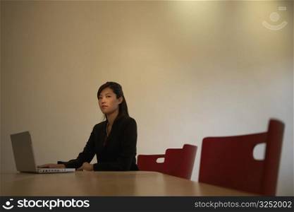 Portrait of a businesswoman using a laptop in a board room