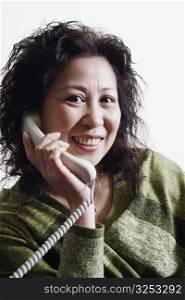 Portrait of a businesswoman using a telephone smiling