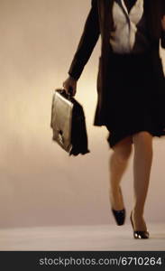 Portrait of a businesswoman walking holding a briefcase