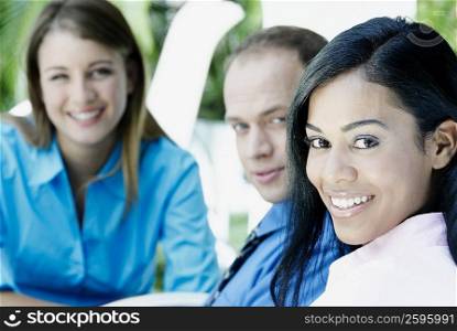 Portrait of a businesswoman with a businessman and a teenage girl smiling