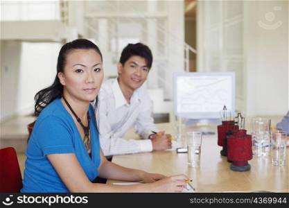 Portrait of a businesswoman with a businessman at a conference table