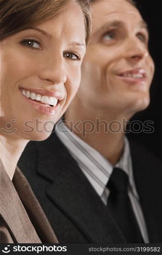 Portrait of a businesswoman with a businessman behind her