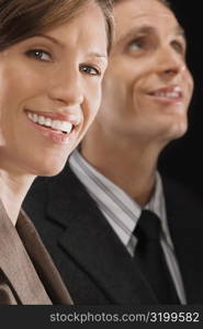 Portrait of a businesswoman with a businessman behind her