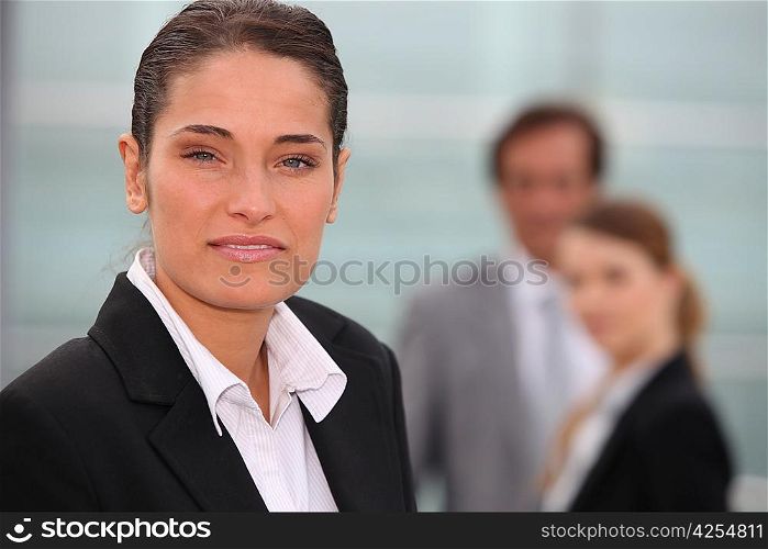Portrait of a businesswoman with colleagues out of focus in the background