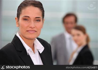 Portrait of a businesswoman with colleagues out of focus in the background