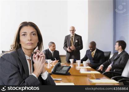 Portrait of a businesswoman with other business executives in a board room