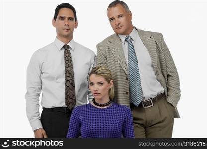 Portrait of a businesswoman with two businessmen standing behind her