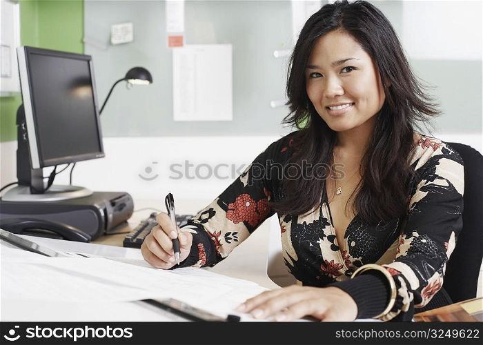 Portrait of a businesswoman writing with a pen