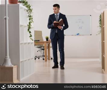 Portrait of a busy businessman taking notes and writing something in his organizer at his office