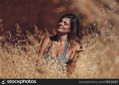 Portrait of a Calm Beautiful Female Model. Golden Wheat Field. Girl Enjoying Sunny Day.