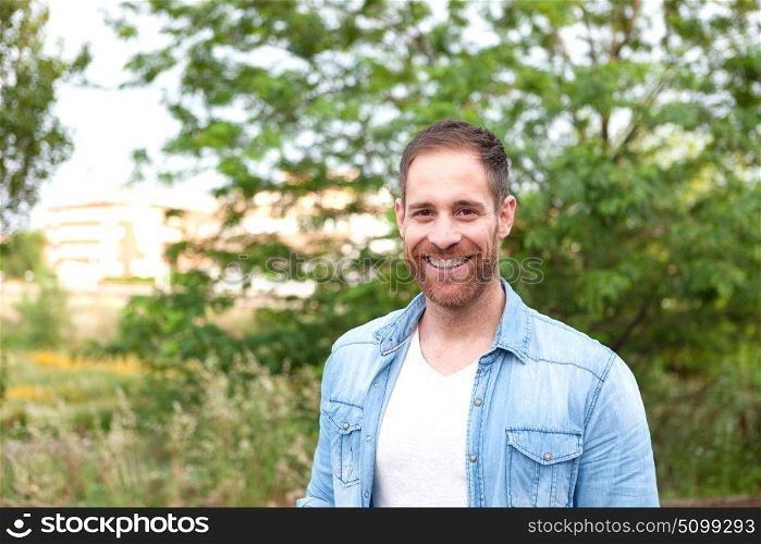 Portrait of a casual men with denim shirt in a park