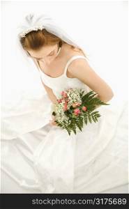 Portrait of a Caucasian bride holding bouquet.