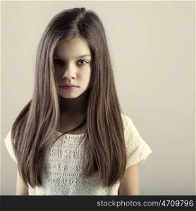 Portrait of a charming brunette little girl, isolated on gray background