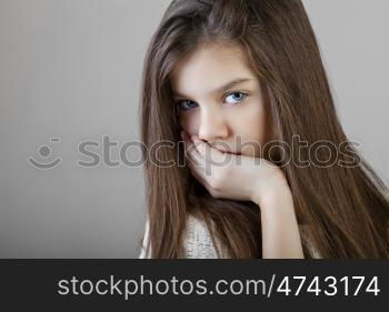 Portrait of a charming brunette little girl, isolated on gray background