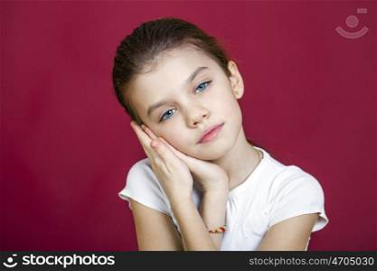 Portrait of a charming brunette little girl looking at camera, isolated on red background