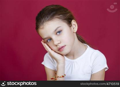 Portrait of a charming brunette little girl looking at camera, isolated on red background