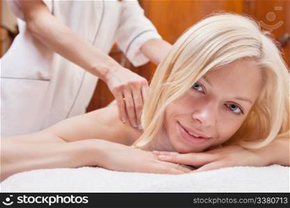 Portrait of a charming woman having a massage in a spa