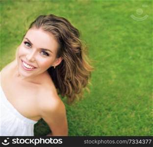 Portrait of a charming woman relaxing on the fresh, green lawn