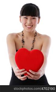 Portrait of a charming young girl on a white background holding a heart