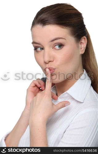 Portrait of a cheeky businesswoman with her finger on her lips