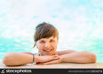 Portrait of a cheerful and beautiful girl in the pool water
