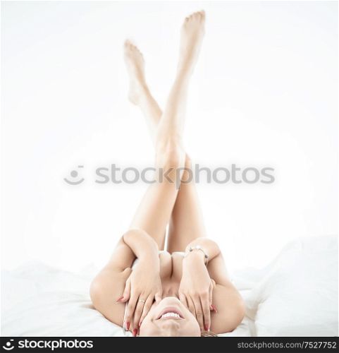 Portrait of a cheerful blond lady laying on the soft bed