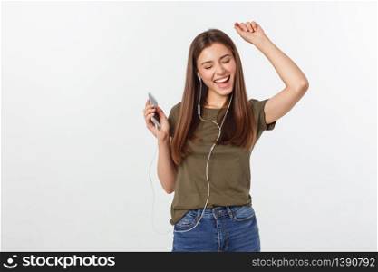 Portrait of a cheerful cute woman listening music in headphones and dancing isolated on a white background. Portrait of a cheerful cute woman listening music in headphones and dancing isolated on a white background.