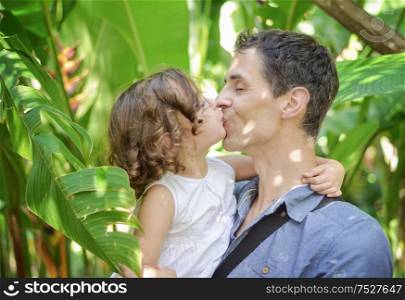 Portrait of a cheerful daughter kissing her father