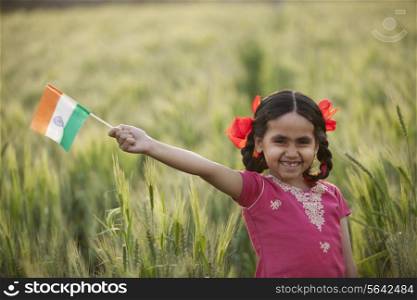 Portrait of a cheerful little girl holding an Indian flag