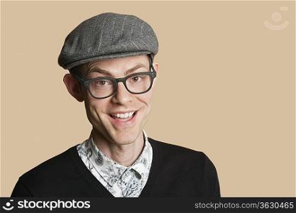 Portrait of a cheerful mid adult man wearing retro glasses over colored background
