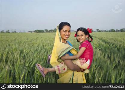 Portrait of a cheerful mother and daughter in the field