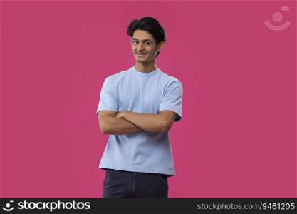 Portrait of a cheerful teenage boy gesturing while standing against pink background