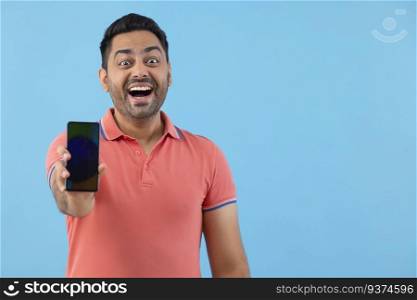 Portrait of a cheerful young man showing his Smartphone in front of camera