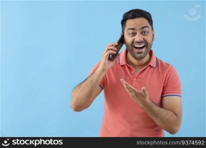 Portrait of a cheerful young man talking on Smartphone