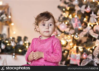 Portrait of a child on the Christmas sparkling lights of the Christmas tree.. Portrait of a child on a background of Christmas lights garlands on the tre